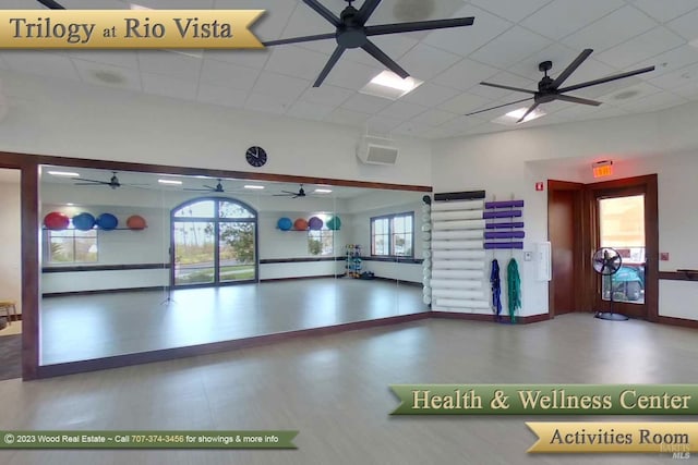 exercise room with wood finished floors, baseboards, and a drop ceiling