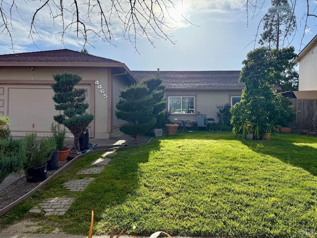 view of front of house with stucco siding and a front yard