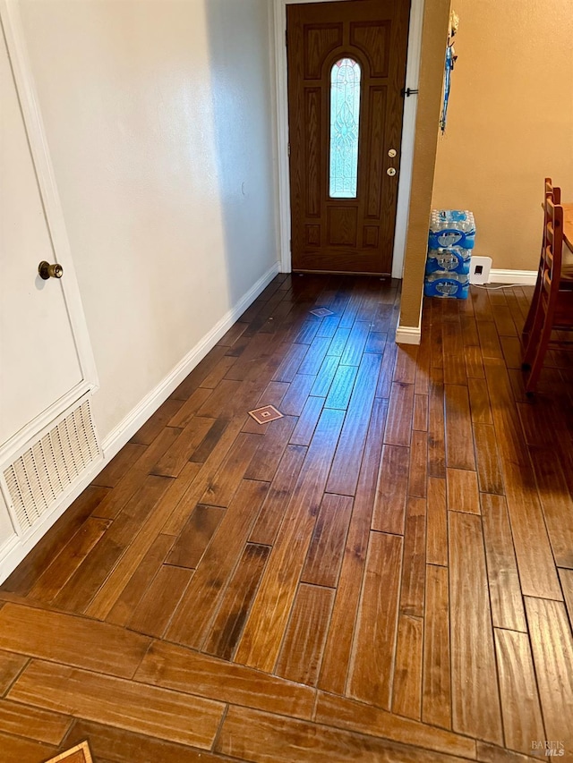 foyer entrance featuring visible vents, baseboards, and hardwood / wood-style flooring