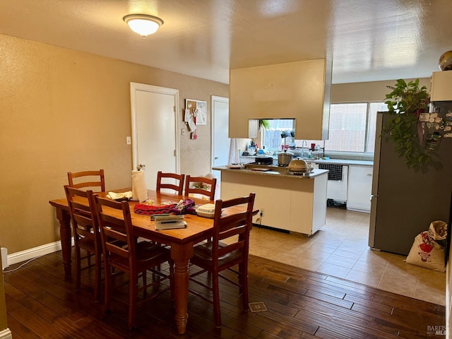 dining space with baseboards and light wood finished floors