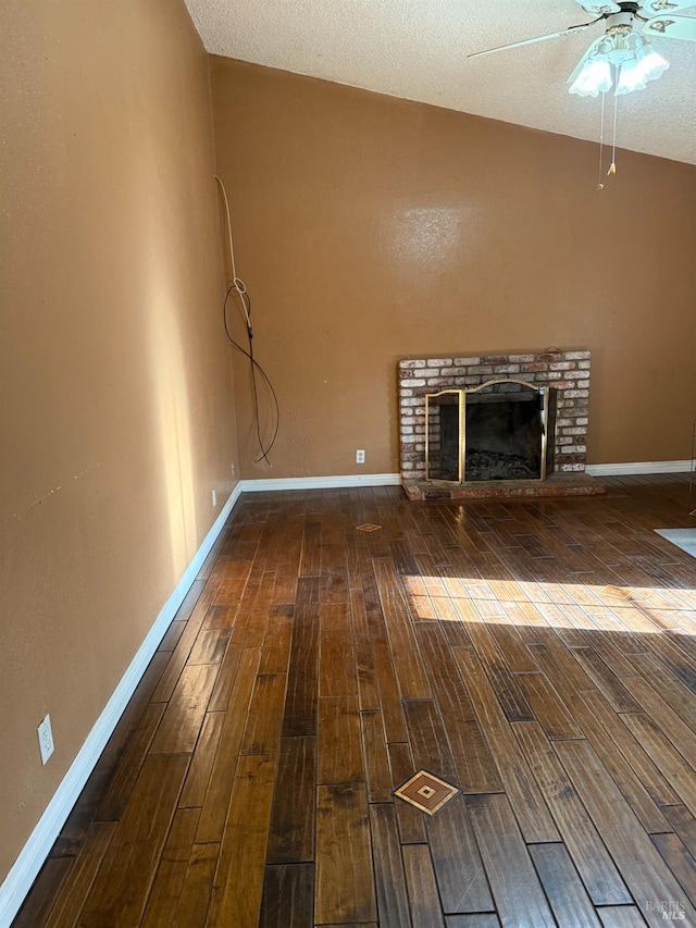 unfurnished living room featuring vaulted ceiling, wood finished floors, a fireplace, and baseboards