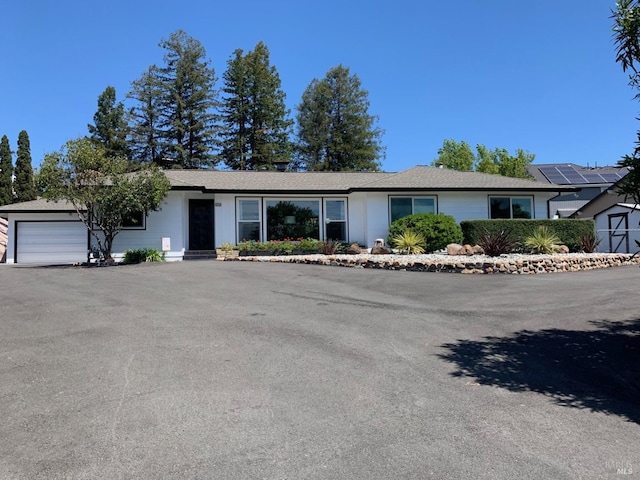 single story home featuring aphalt driveway and an attached garage