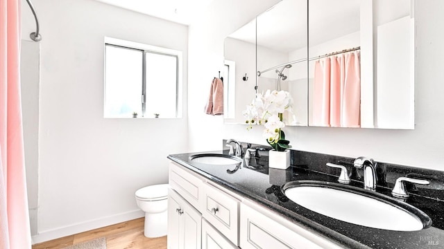 full bathroom featuring toilet, a shower with curtain, a sink, and wood finished floors