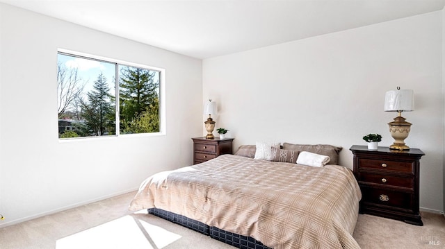bedroom with baseboards and light carpet