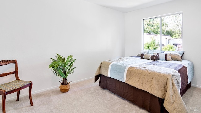 bedroom featuring baseboards and light carpet