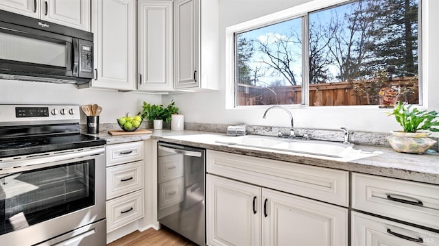 kitchen featuring white cabinets, appliances with stainless steel finishes, and a sink