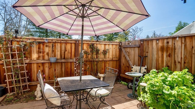 view of patio / terrace featuring a gate, a fenced backyard, and outdoor dining space