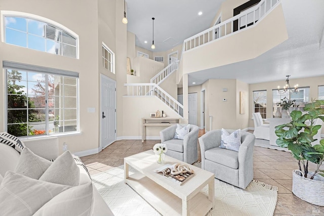 living area featuring tile patterned flooring, baseboards, stairs, a high ceiling, and an inviting chandelier