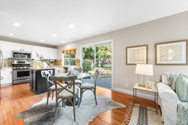 dining space with recessed lighting, light wood-type flooring, and baseboards