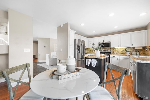 dining area featuring recessed lighting, baseboards, and wood finished floors