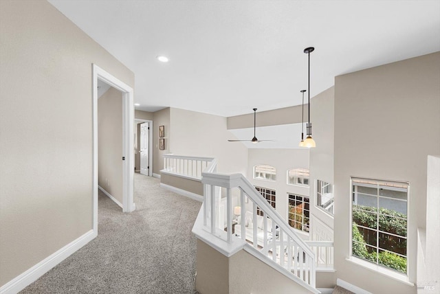 corridor featuring recessed lighting, carpet, baseboards, and an upstairs landing