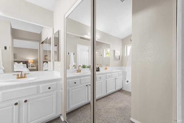 bathroom featuring a sink, two vanities, and ensuite bath