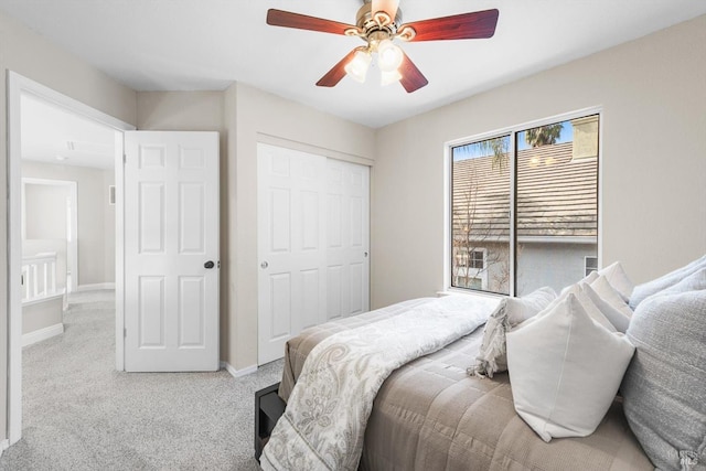 carpeted bedroom featuring a ceiling fan, baseboards, and a closet