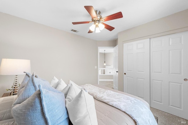 bedroom featuring a closet, visible vents, carpet flooring, and a ceiling fan