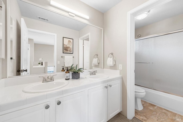 bathroom featuring double vanity, toilet, visible vents, and a sink