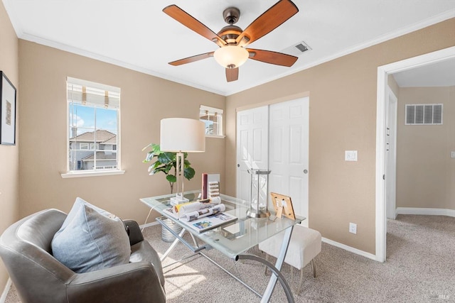 carpeted home office with ceiling fan, baseboards, visible vents, and ornamental molding