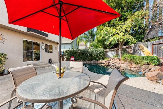 view of patio featuring outdoor dining space, a fenced backyard, and a fenced in pool