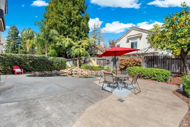 view of patio with outdoor dining area and a fenced backyard