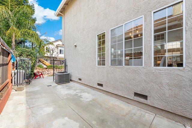 view of patio / terrace featuring central air condition unit and fence