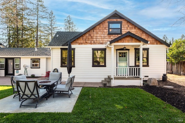 rear view of property with a patio, an outdoor fire pit, roof with shingles, and fence