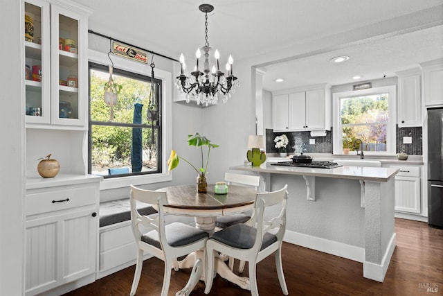 dining room featuring dark wood finished floors, a notable chandelier, and baseboards