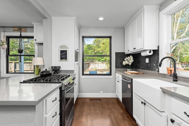 kitchen with backsplash, appliances with stainless steel finishes, white cabinets, and dark wood-type flooring