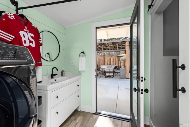 bathroom featuring vanity, crown molding, washer / clothes dryer, and wood finished floors