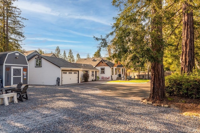 view of front of house featuring an outbuilding, an attached garage, driveway, and a storage unit