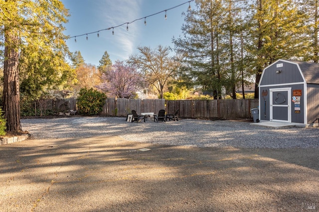 view of yard featuring a storage unit, an outbuilding, and fence