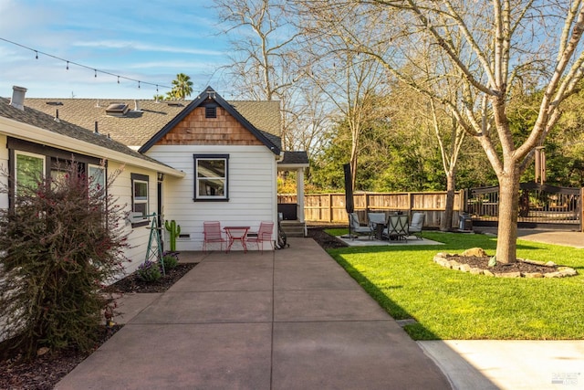 exterior space featuring fence, roof with shingles, a yard, crawl space, and a patio area