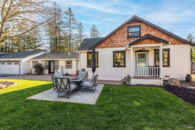 back of house with a patio, a fire pit, roof with shingles, and a lawn