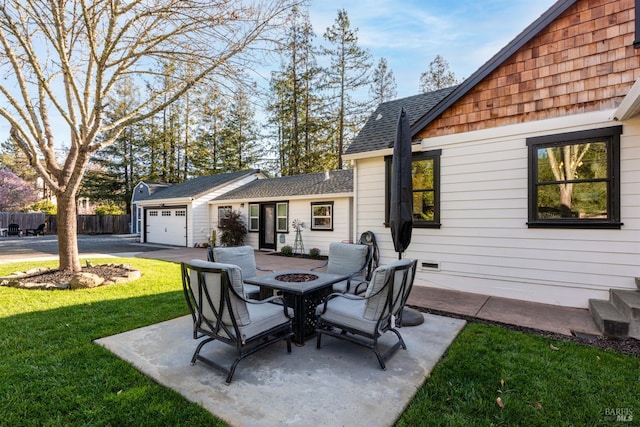 view of patio featuring an attached garage, an outdoor fire pit, and fence