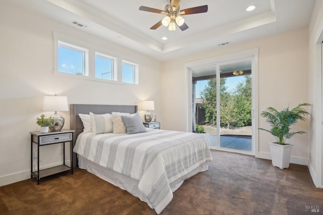 bedroom featuring visible vents, dark carpet, a tray ceiling, and access to outside