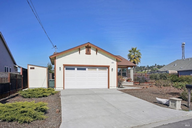 view of front of property with an attached garage, fence, and driveway