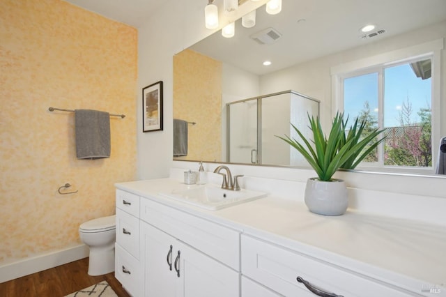 bathroom with toilet, wood finished floors, visible vents, and a stall shower