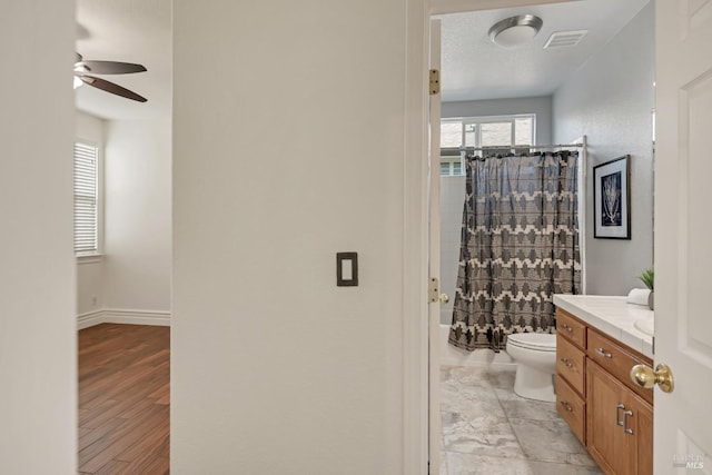 full bathroom with vanity, baseboards, visible vents, shower / bath combination with curtain, and toilet