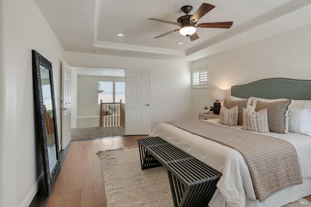 bedroom featuring wood finished floors, baseboards, recessed lighting, ceiling fan, and a raised ceiling