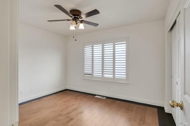 unfurnished bedroom with visible vents, ceiling fan, baseboards, wood finished floors, and a closet