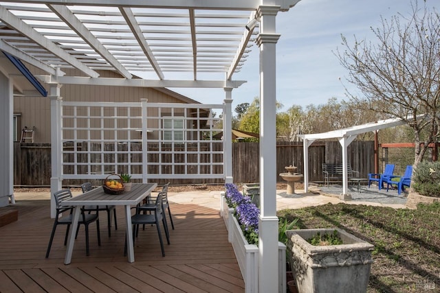 deck with outdoor dining space, a pergola, and fence