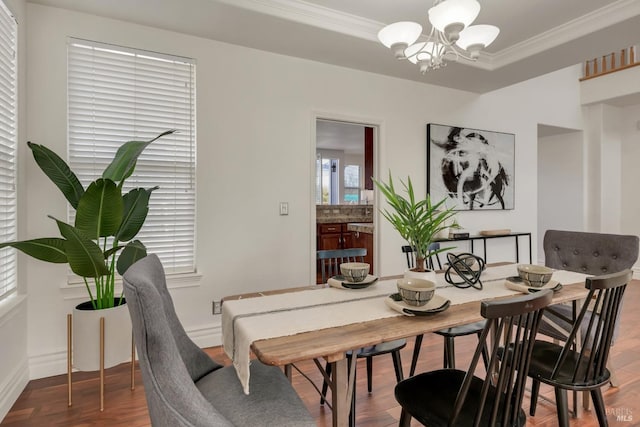 dining area featuring wood finished floors, an inviting chandelier, and ornamental molding