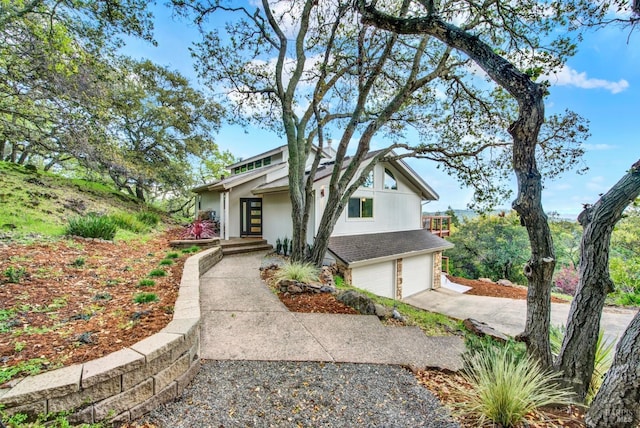 view of front of property with stucco siding, an attached garage, and driveway