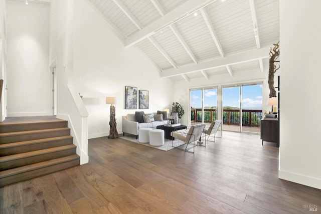 living area featuring wood finished floors, baseboards, and high vaulted ceiling