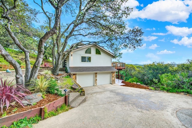 view of property exterior with concrete driveway, an attached garage, and stone siding