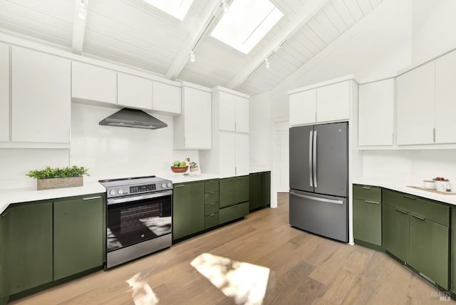 kitchen featuring appliances with stainless steel finishes, light countertops, wall chimney exhaust hood, and green cabinetry