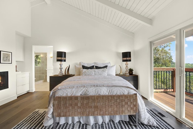 bedroom with wood finished floors, a lit fireplace, access to exterior, ensuite bathroom, and beamed ceiling