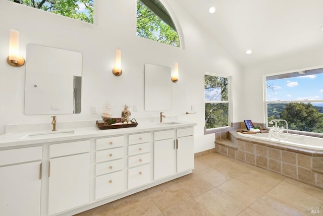 bathroom with a sink, tile patterned floors, double vanity, and a relaxing tiled tub