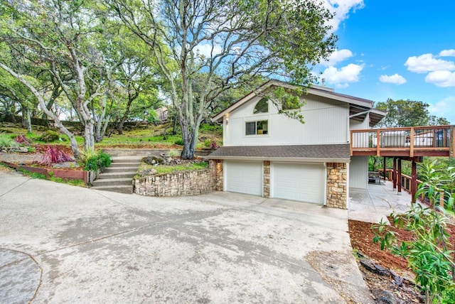 view of home's exterior with stairway, driveway, a wooden deck, an attached garage, and stone siding