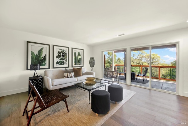 living area with visible vents, baseboards, and wood finished floors