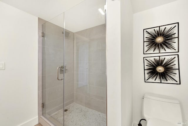 full bath with a stall shower, toilet, and baseboards