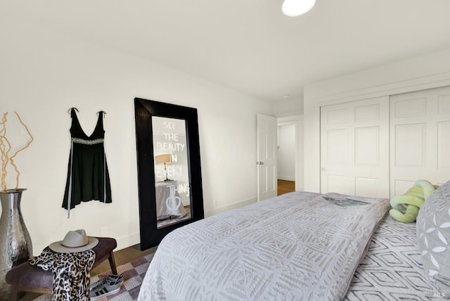 bedroom with a closet, baseboards, and wood finished floors